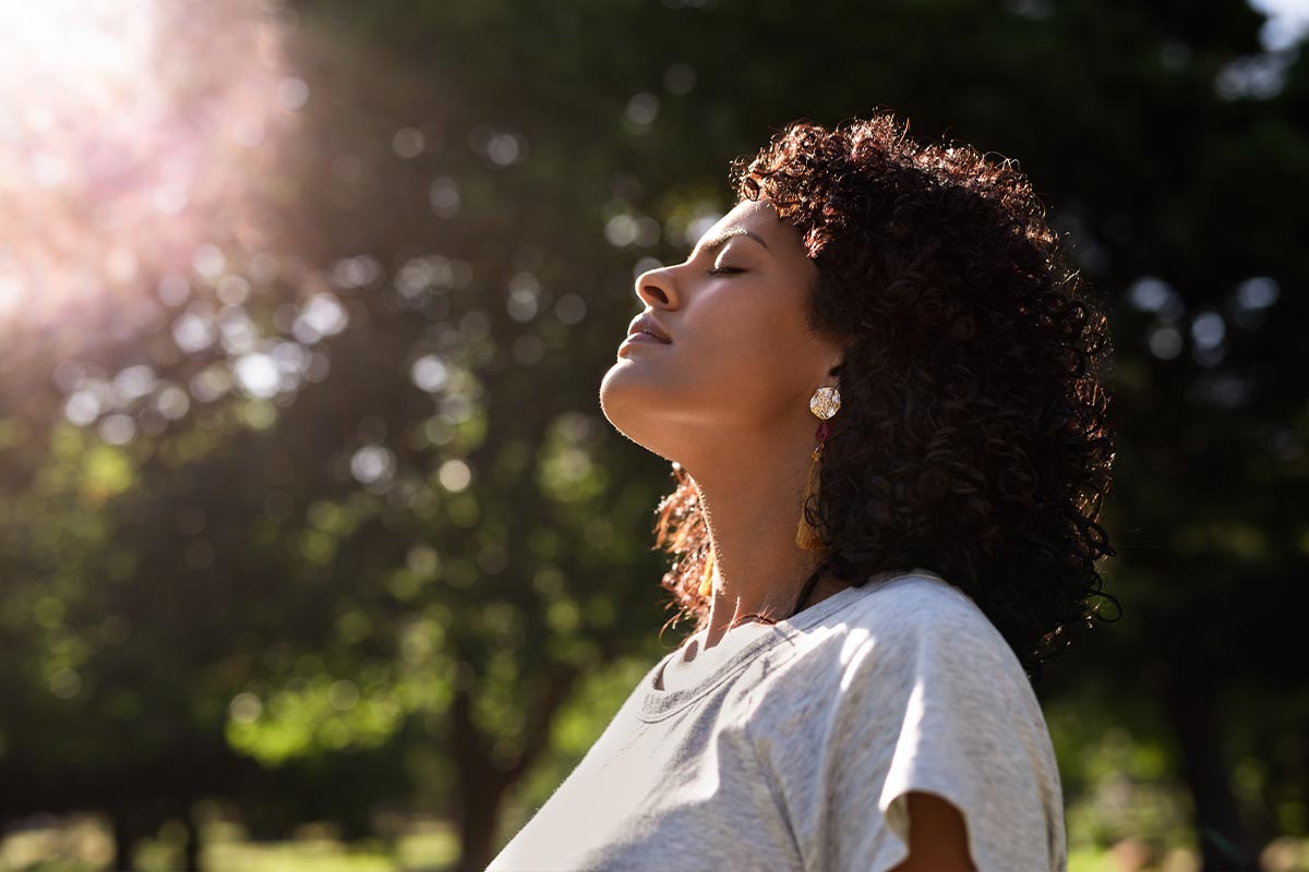 Woman breathing outside after duct cleaning and improved indoor air quality